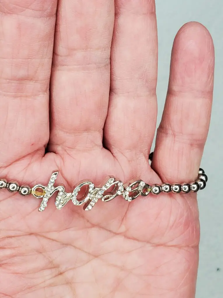 Silver bracelet with "hope" inscription displayed.