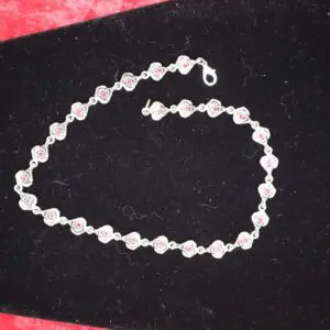 Silver bracelet adorned with pink floral accents.
