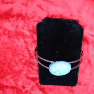 Turquoise stone bracelet on a black display.