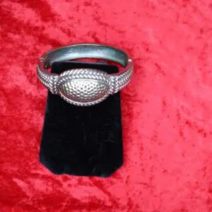 Intricate silver bracelet with textured design details.
