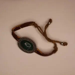 Brown bracelet with decorative green stone centerpiece.