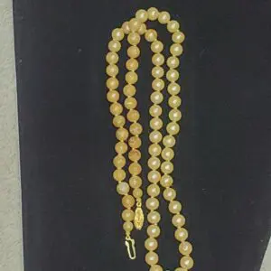 Elegant yellow bead necklace with gold clasp.