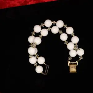 White beaded bracelet with golden clasp accents.