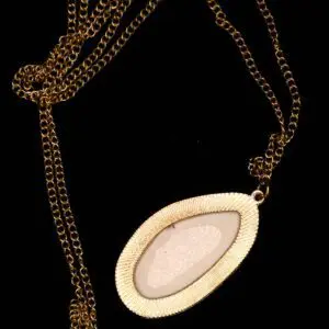 Gold chain necklace with oval pendant design.