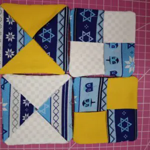 Colorful quilted fabric squares arranged in pattern.