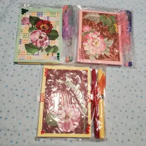 Colorful floral notepads with decorative pens.