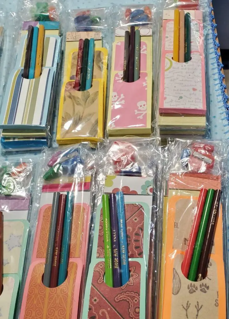Colorful notepad sets with decorative writing tools.