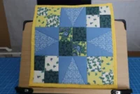 A patchwork quilt with blue, green, and yellow floral patterns.