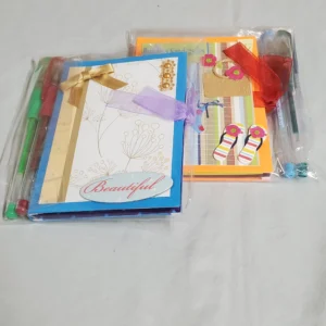 Two colorful gift bags with tissue paper and ribbons on a white surface.