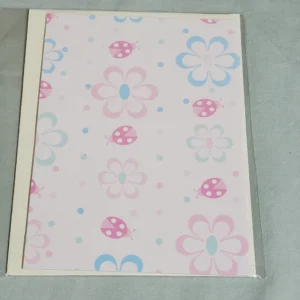 A pastel notebook with flower and ladybug patterns on the cover.