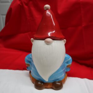 A small gnome figurine with a red hat and blue outfit.